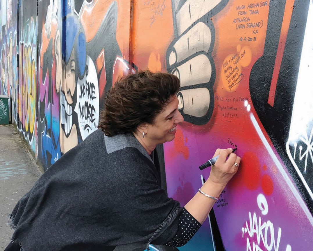 Sevim Erhan signs the Peace Wall in Belfast, Ireland.