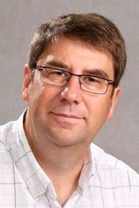 Philip Calder, Professor of Nutritional Immunology, wearing glasses and a plaid shirt, against a neutral gray background.